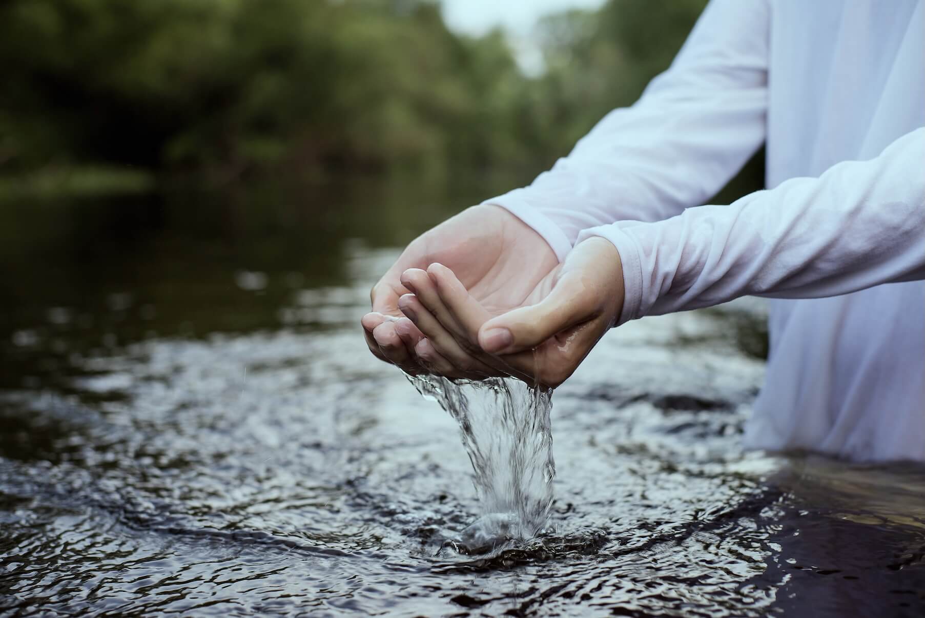 A woman in the water getting ready for baptism